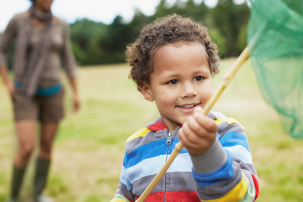 child holding net outside